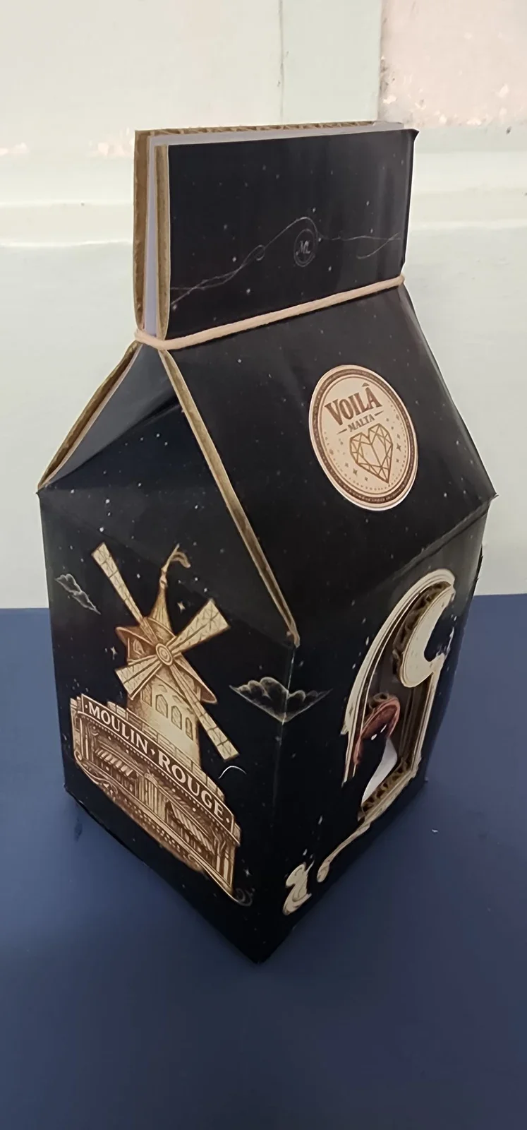 Caja de regalo para una malta, vista en perspectiva con ventana frontal y gráfica del Moulin Rouge.